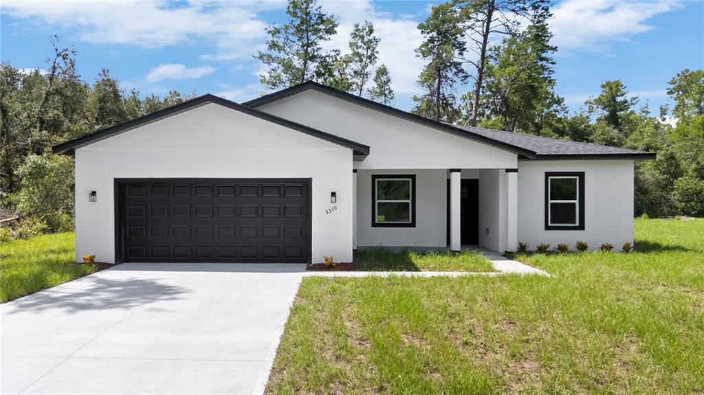 3310 Southwest 177th Lane Road Ocala, FL 34473 - Photo 34 of 40 a front view of house with yard and trees in the background