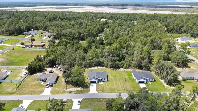 an aerial view of residential houses with outdoor space and swimming pool