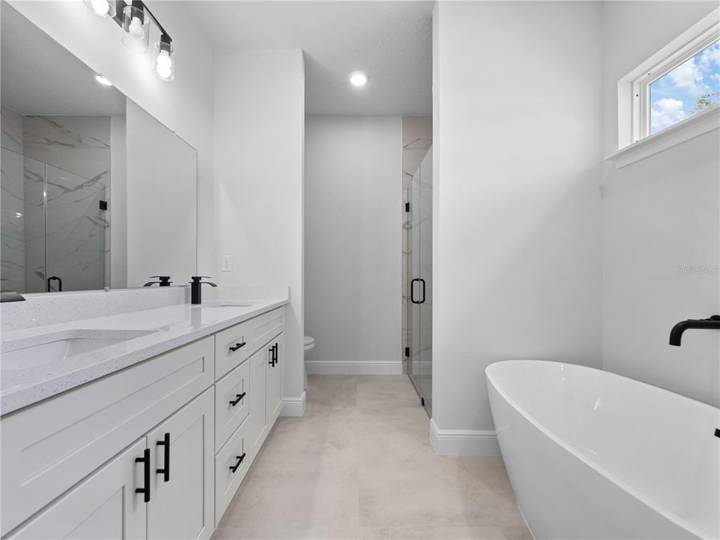 3310 Southwest 177th Lane Road Ocala, FL 34473 - Photo 6 of 40 a bathroom with double vanity two mirror and a bathtub