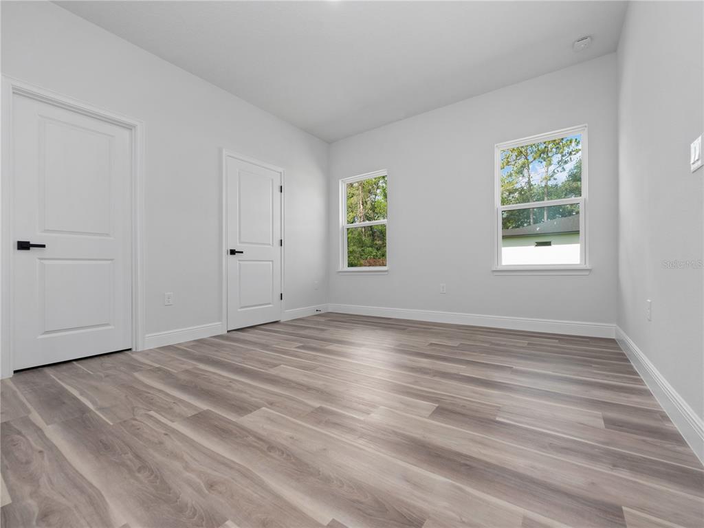 3310 Southwest 177th Lane Road Ocala, FL 34473 - Photo 9 of 40 a view of an empty room with wooden floor and window