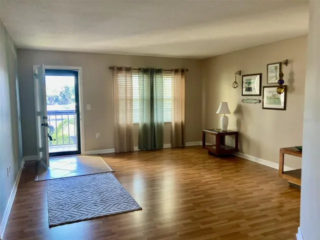 a view of an empty room with window and a livingroom
