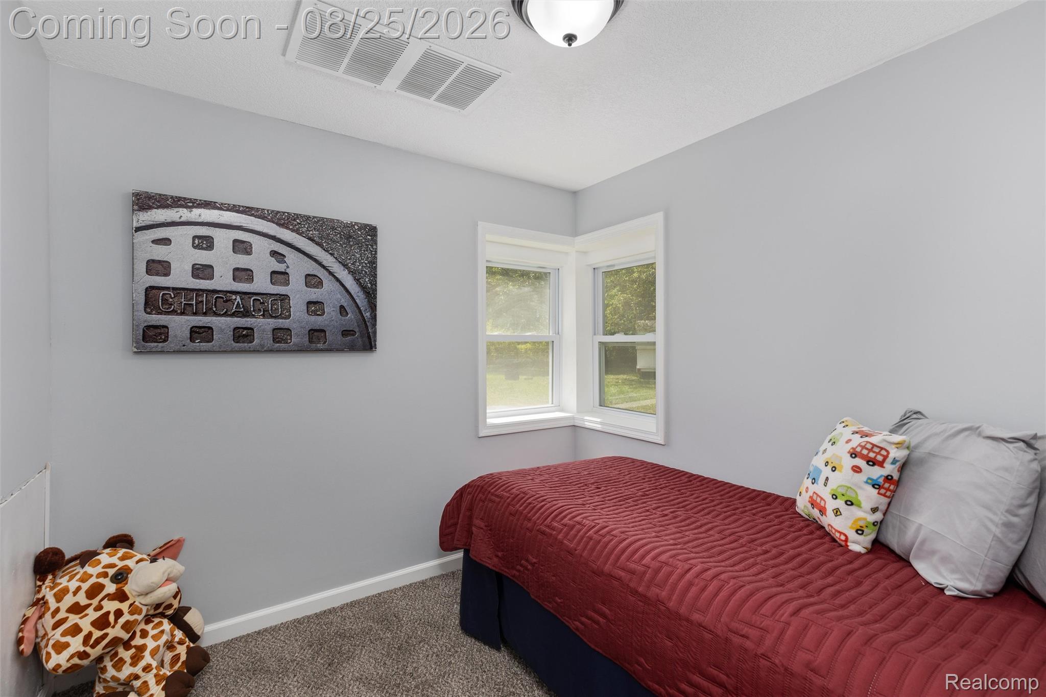 1156 Rinn Street Burton, MI 48509 - Photo 11 of 25 Recessed corner windows, light gray wall paint, and gray carpeting