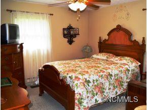 118 Riverside Drive Canton, NC 28716 - Photo 12 of 21 a bedroom with a bed and a chandelier