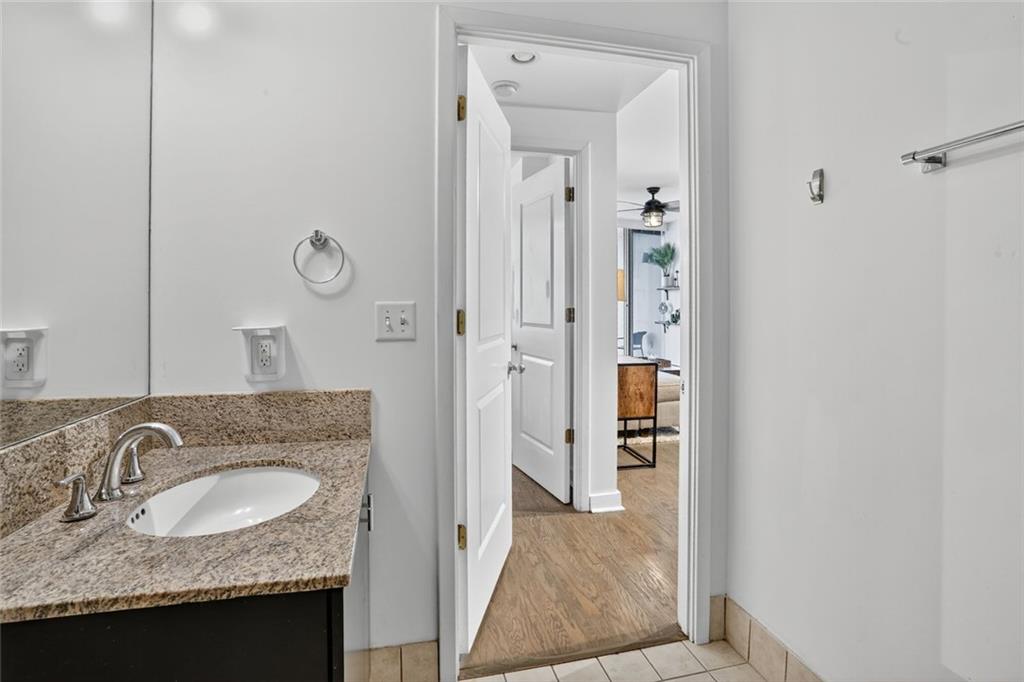 3338 Peachtree Road Northeast, Unit 1706 Atlanta, GA 30326 - Photo 13 of 35 a bathroom with a granite countertop sink and a mirror
