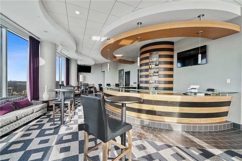 3338 Peachtree Road Northeast, Unit 1706 Atlanta, GA 30326 - Photo 27 of 35 a view of a kitchen with kitchen island stainless steel appliances table chairs and a rug