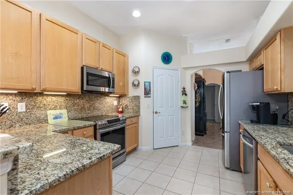 a kitchen with stainless steel appliances granite countertop a stove a sink and a microwave