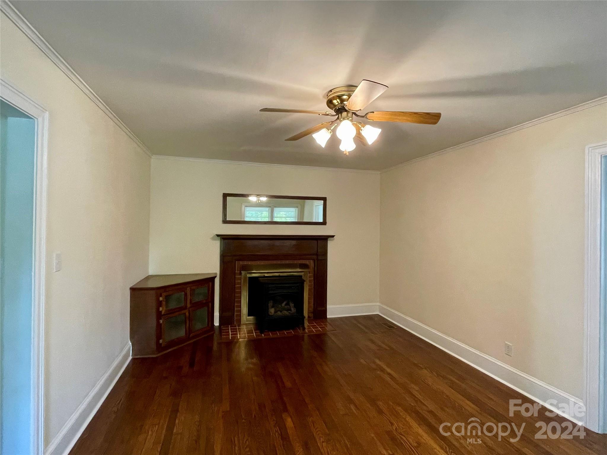 304 Rhyne Street Stanley, NC 28164 - Photo 11 of 38 an empty room with wooden floor fan and a window