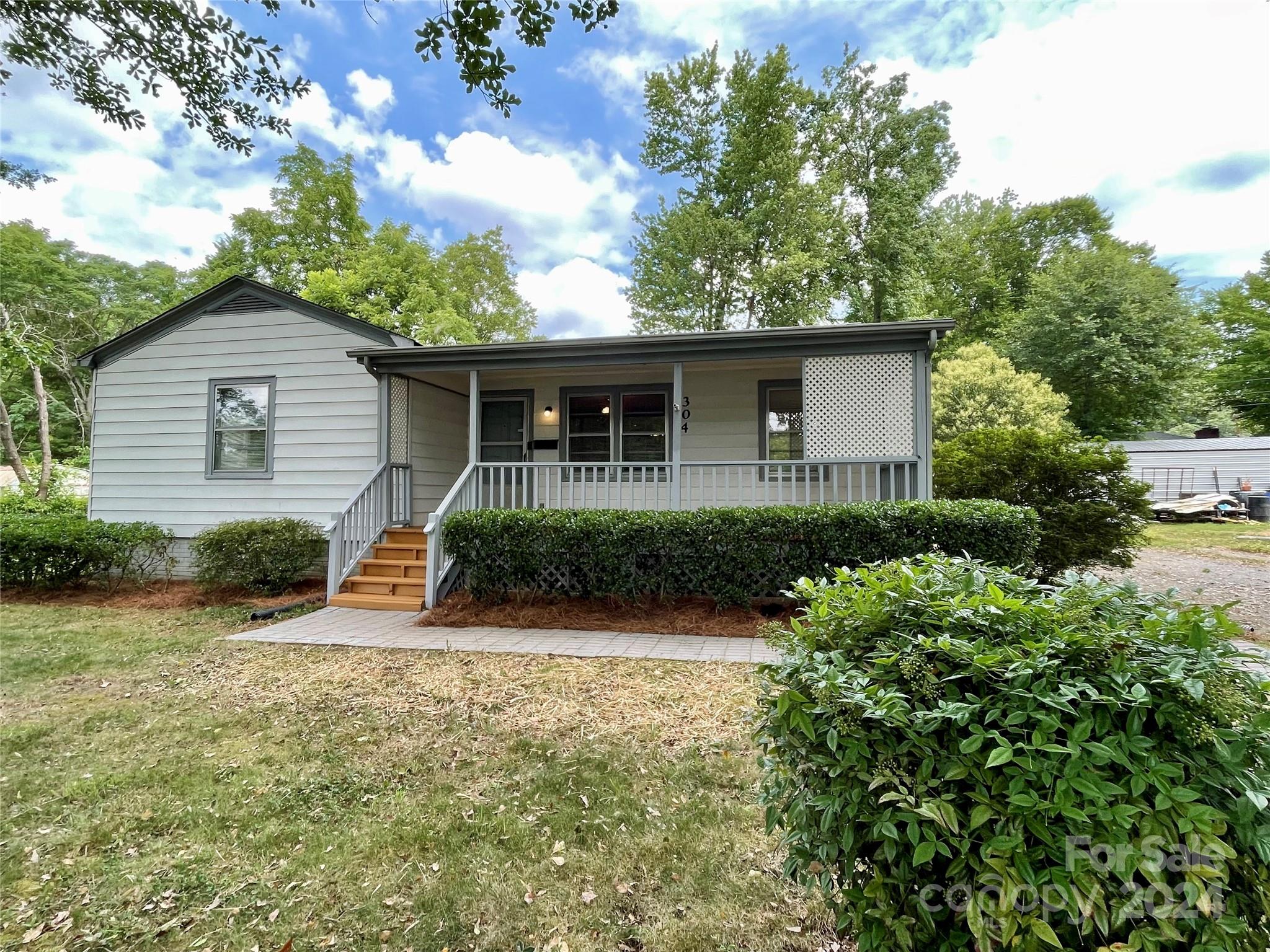304 Rhyne Street Stanley, NC 28164 - Photo 2 of 38 a front view of a house with a yard and potted plants