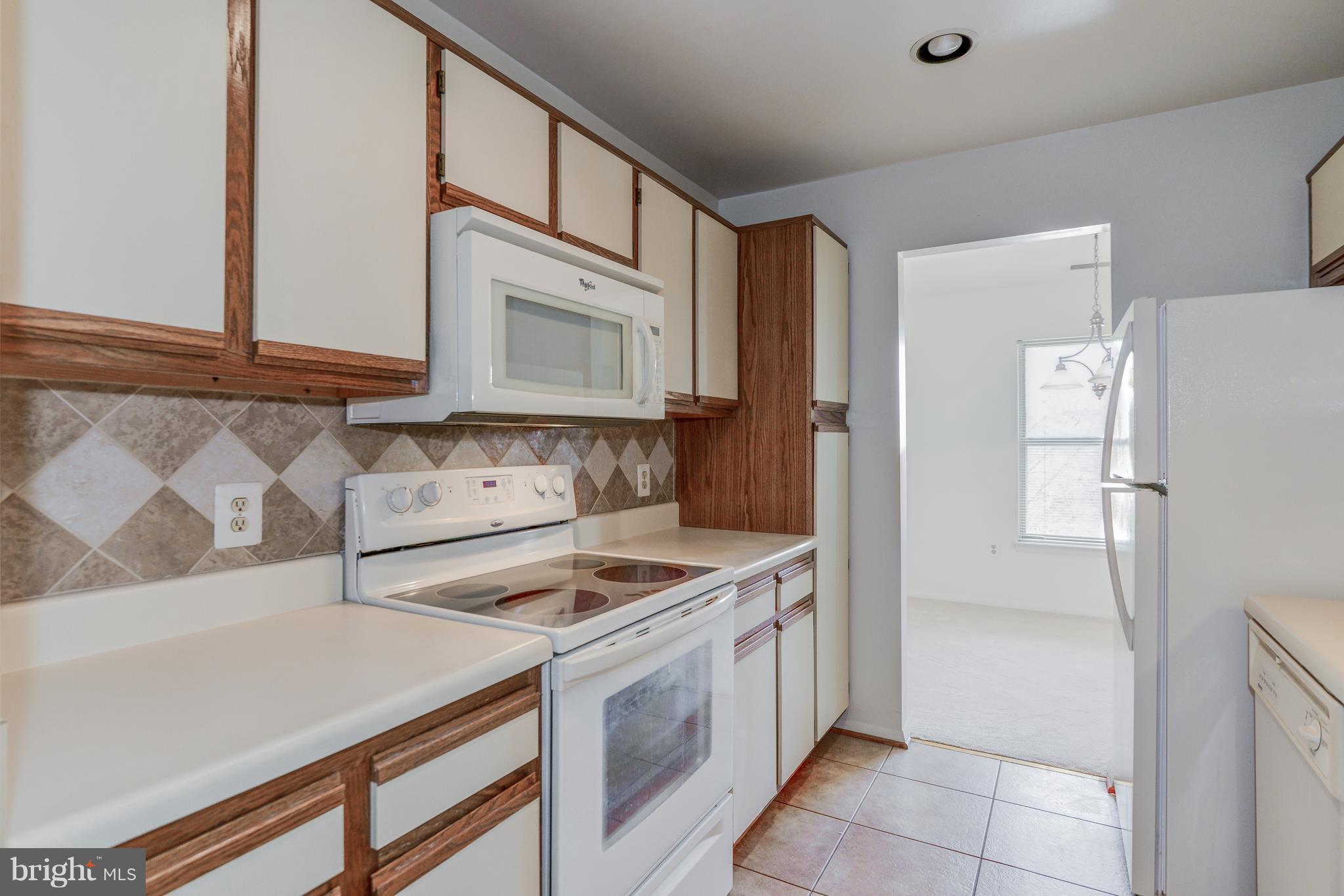 7804 Guildberry Court, Unit 303 Gaithersburg, MD 20879 - Photo 11 of 21 a kitchen with stainless steel appliances granite countertop a refrigerator and a sink