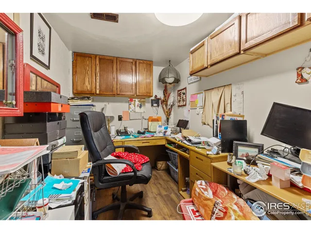 a view of a workspace with furniture and a window