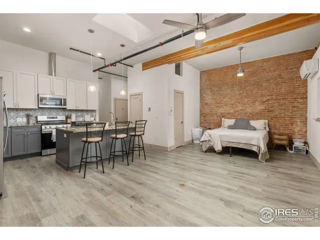 a kitchen with stainless steel appliances a refrigerator a stove a sink dishwasher and white cabinets with wooden floor