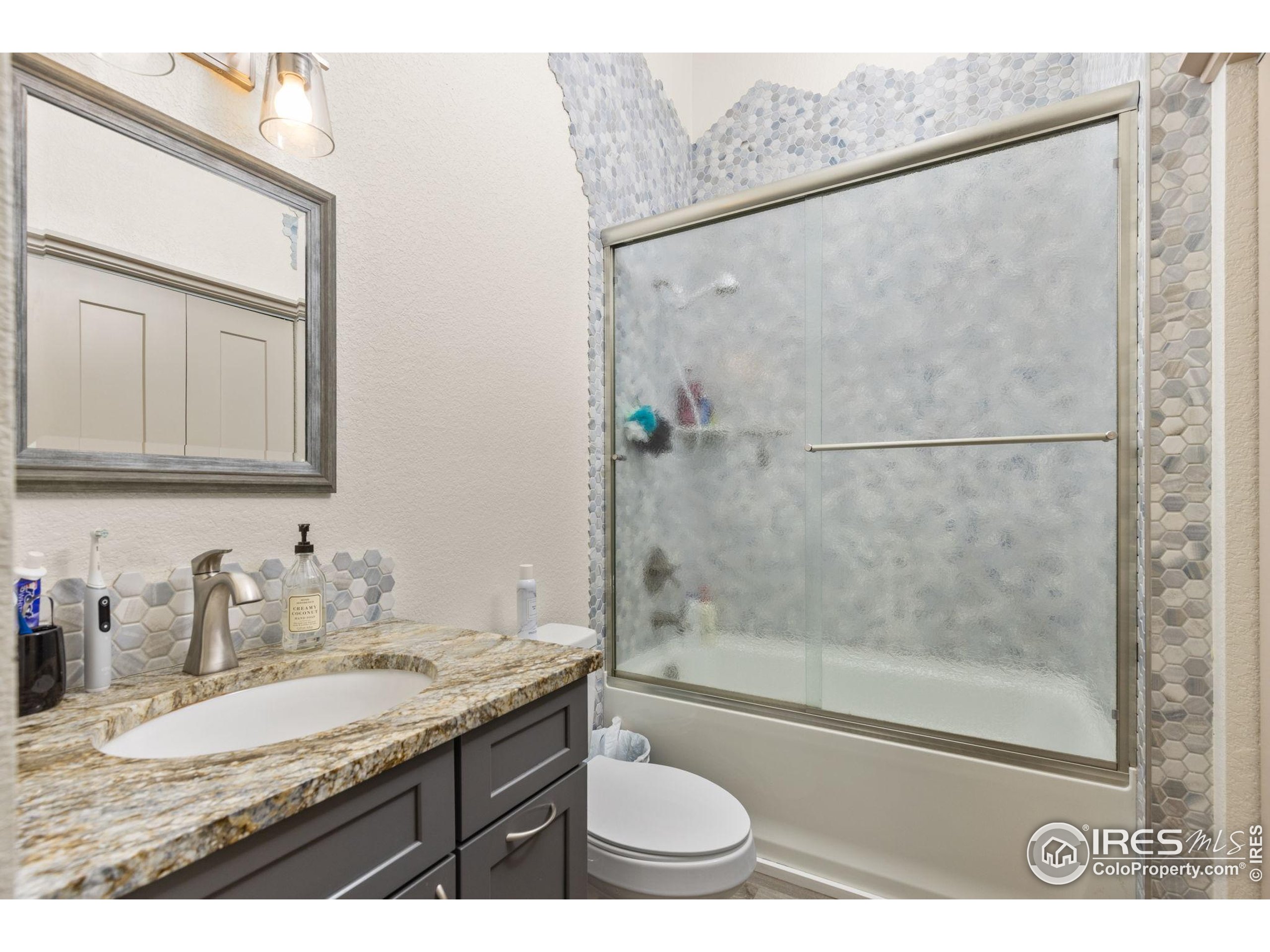 331 Main Street Longmont, CO 80501 - Photo 34 of 50 a bathroom with a granite countertop sink toilet and shower