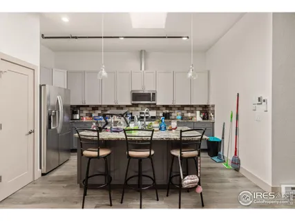 a kitchen with kitchen island granite countertop a sink cabinets and stainless steel appliances