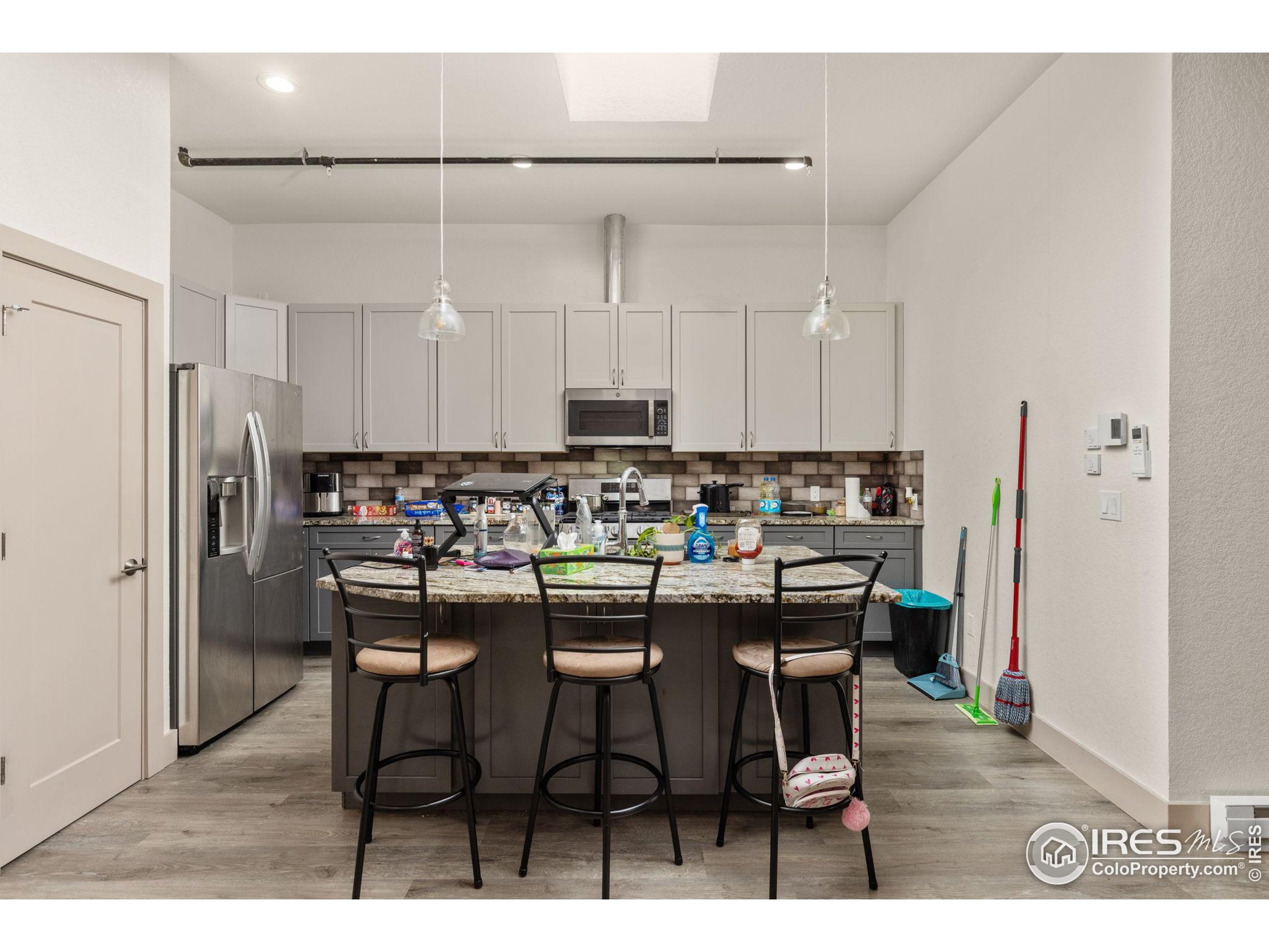 331 Main Street Longmont, CO 80501 - Photo 39 of 50 a kitchen with a dining table chairs refrigerator and cabinets