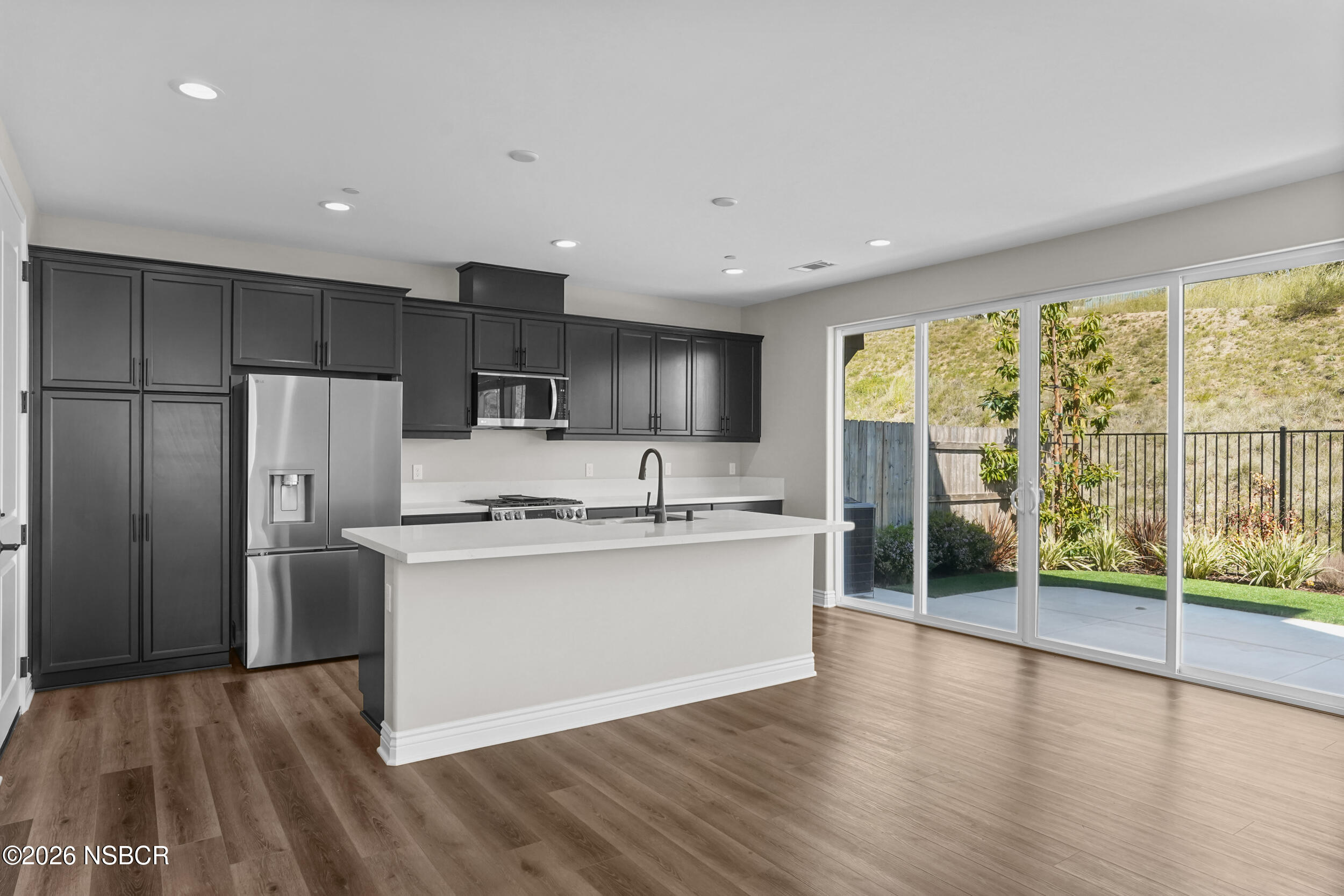 1147 Ginger Place Santa Maria, CA 93455 - Photo 6 of 55 a kitchen with stainless steel appliances granite countertop a refrigerator a sink dishwasher a stove and a large window with wooden floor
