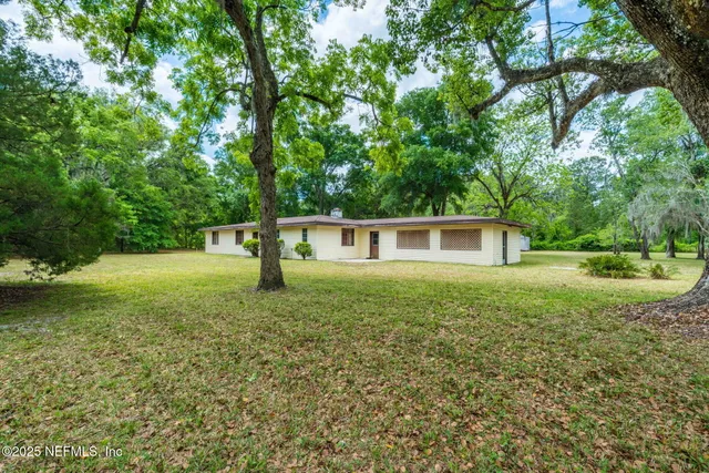 a view of a house with backyard and garden