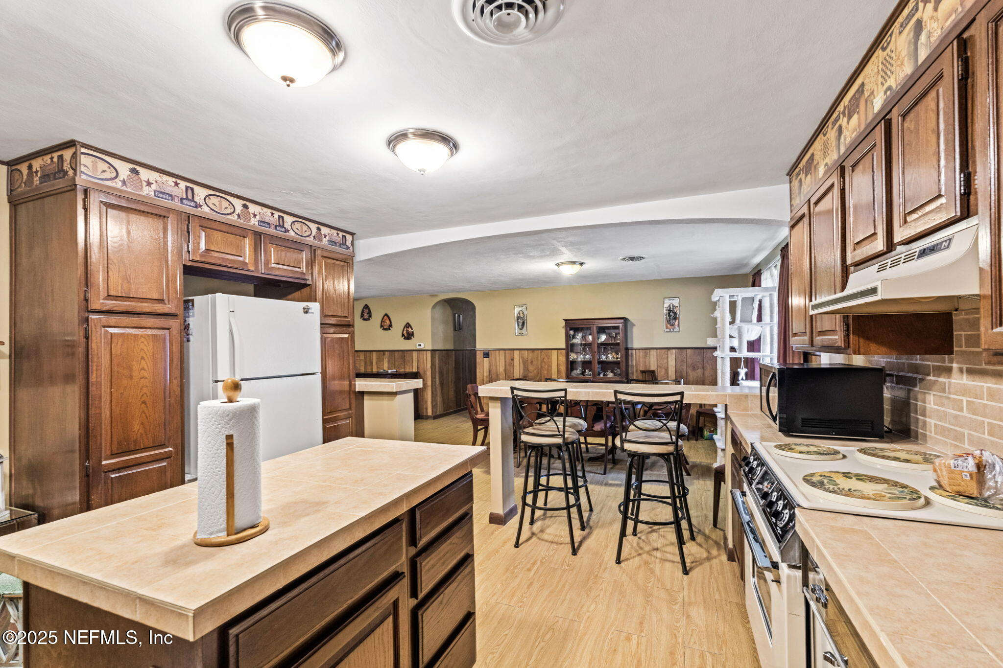 5705 CR 208 St. Augustine, FL 32092 - Photo 24 of 86 a kitchen with stainless steel appliances kitchen island granite countertop a refrigerator a stove a sink a dining table and chairs with wooden floor