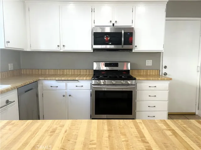 a kitchen with stainless steel appliances granite countertop a stove a microwave and cabinets