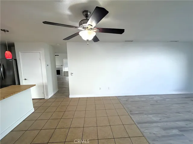 a view of an empty room and kitchen view