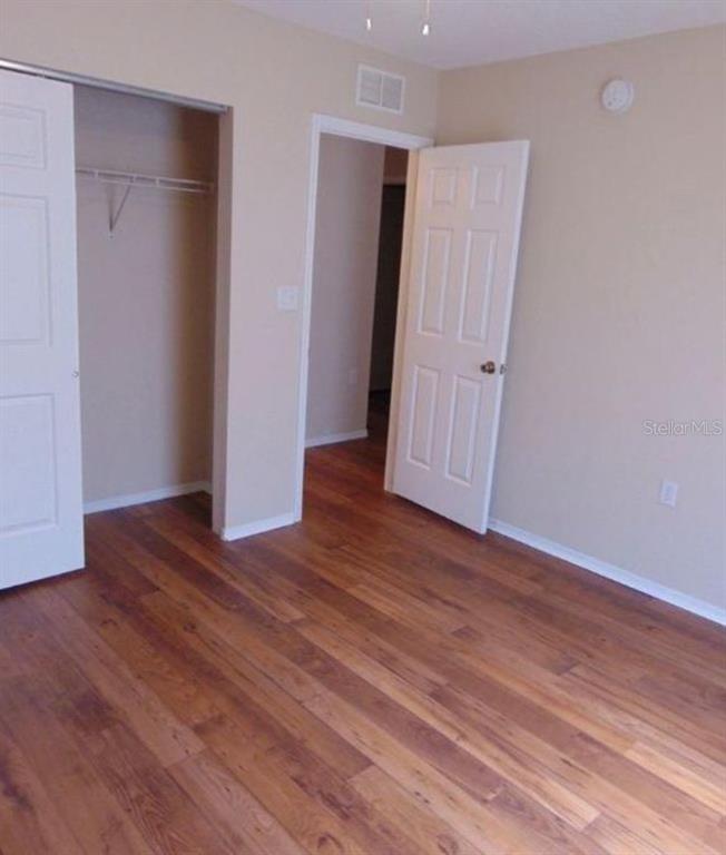 5816 Congress Street, Unit 102 New Port Richey, FL 34653 - Photo 11 of 14 an empty room with wooden floor and closet