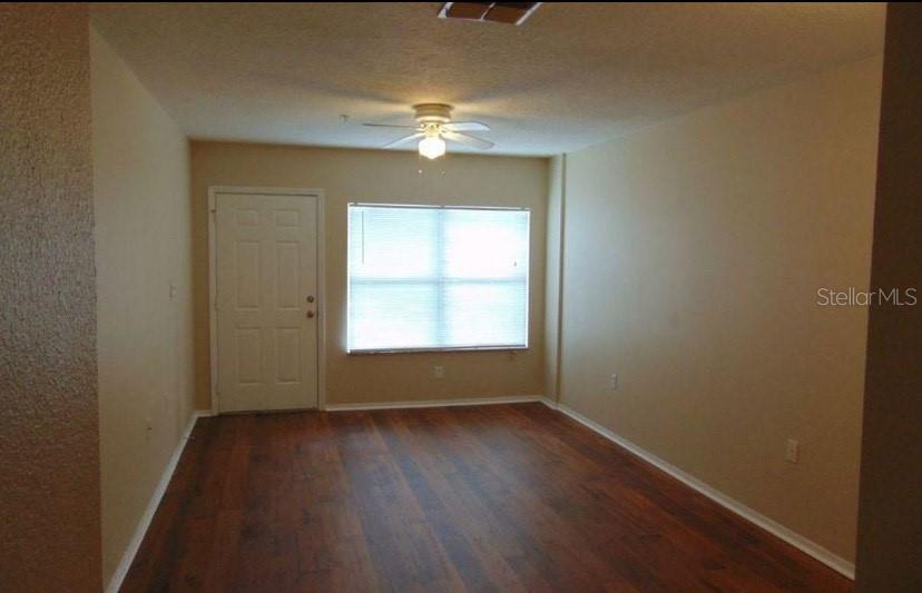 5816 Congress Street, Unit 102 New Port Richey, FL 34653 - Photo 4 of 14 an empty room with wooden floor and windows