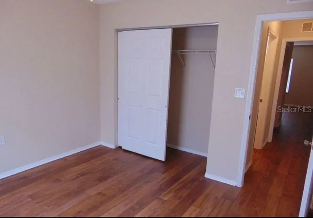 an empty room with wooden floor and a cabinet