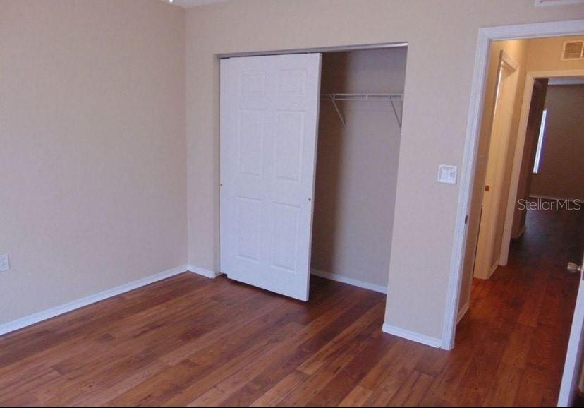 5816 Congress Street, Unit 102 New Port Richey, FL 34653 - Photo 7 of 14 an empty room with wooden floor and a cabinet