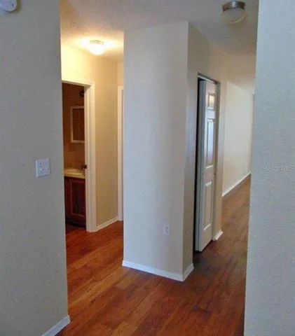 a view of a hallway with wooden floor