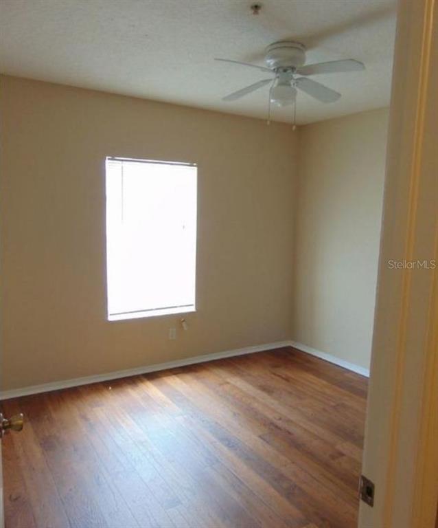 5816 Congress Street, Unit 102 New Port Richey, FL 34653 - Photo 10 of 14 an empty room with wooden floor and windows
