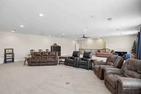 a large bedroom with furniture a flat screen tv and a large window