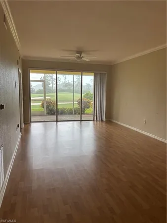 an empty room with wooden floor and door