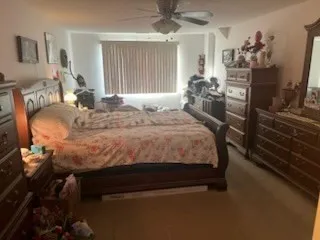 a bedroom with a bed and large mirror on the dresser