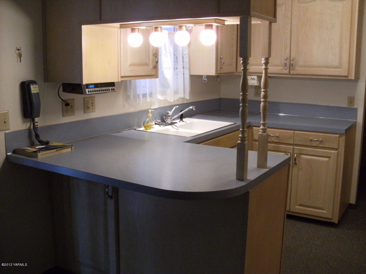 1212 Swan Road Sunnyside, WA 98944 - Photo 3 of 8 a view of a kitchen with kitchen island a sink appliances and a counter top