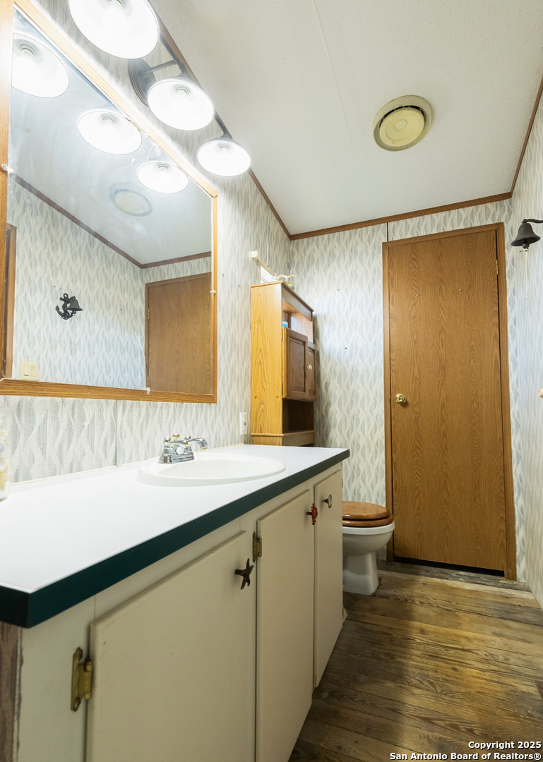 1440 Rendon Road Poteet, TX 78065 - Photo 19 of 22 a bathroom with a sink a toilet and mirror