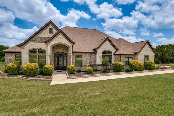 a front view of a house with yard and green space