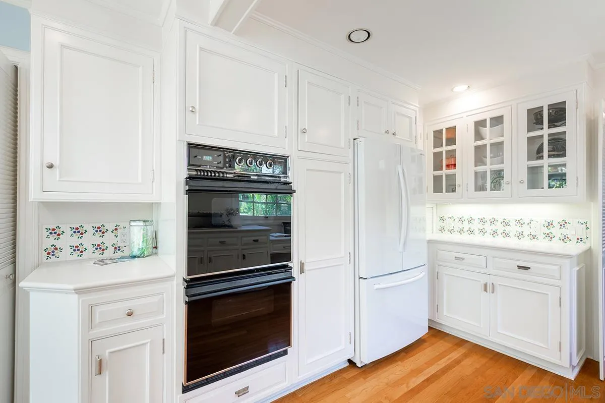 305 West Olive Street San Diego, CA 92103 - Photo 25 of 74 a kitchen with stainless steel appliances white cabinets and a stove top oven