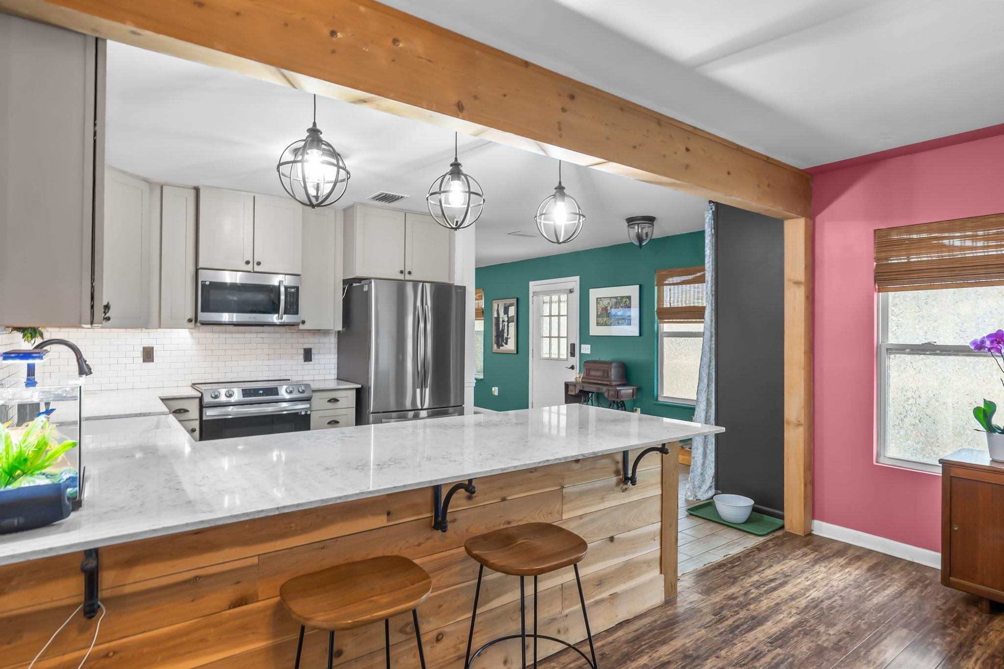 129 Pelican Road St. Augustine, FL 32086 - Photo 17 of 34 Kitchen with light stone countertops, appliances with stainless steel finishes, tasteful backsplash, pendant lighting, and a peninsula