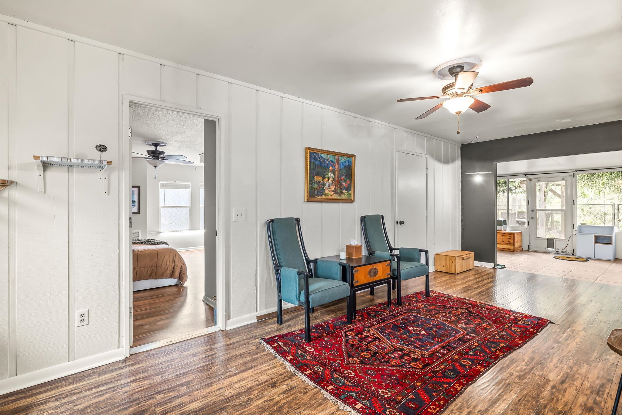 129 Pelican Road St. Augustine, FL 32086 - Photo 18 of 34 Living area featuring ceiling fan, wood finished floors, and a decorative wall