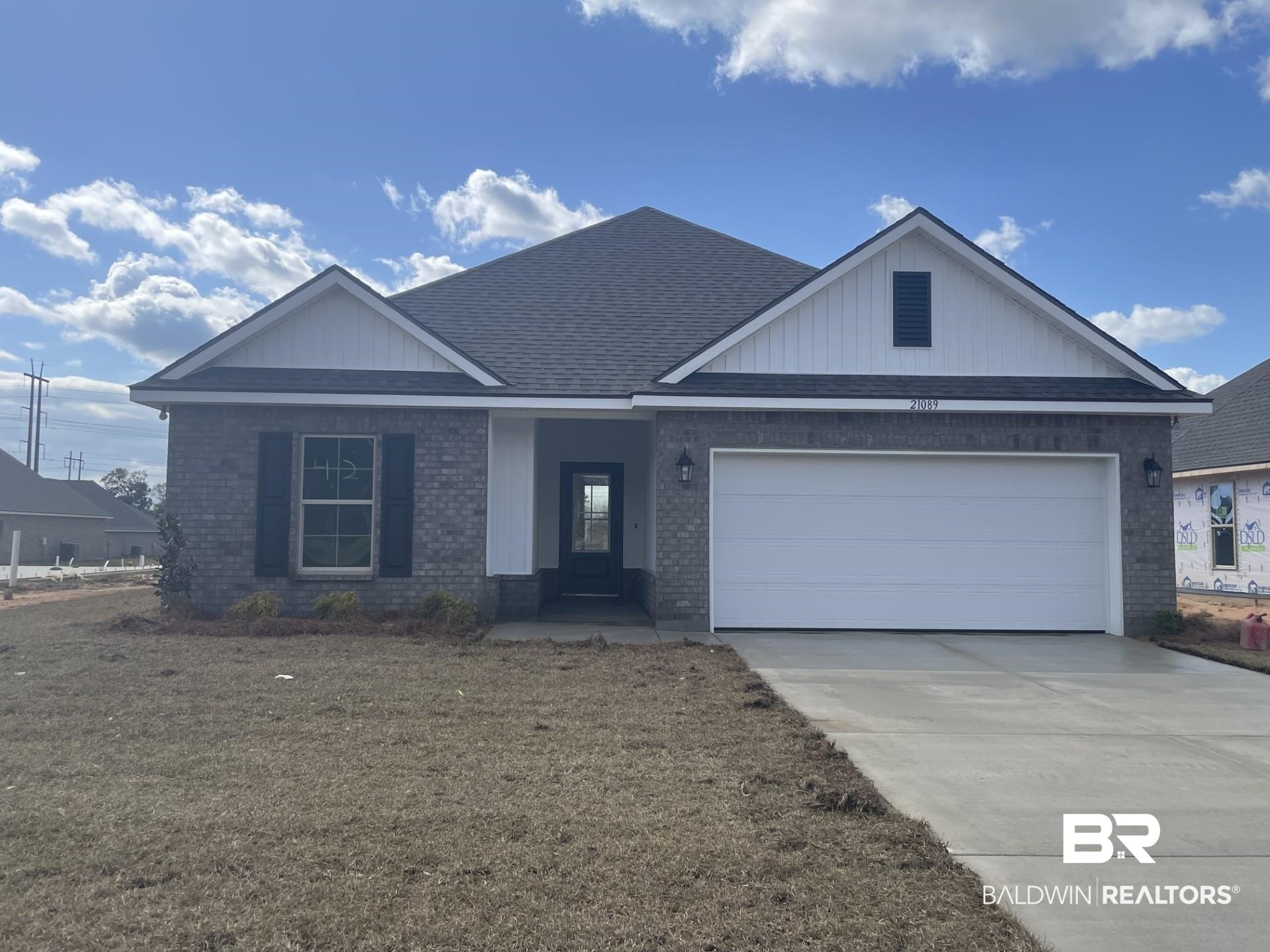 21089 Central Avenue Silverhill, AL 36576 - Photo 1 of 3 View of front of house featuring brick siding, a garage, concrete driveway, and a shingled roof