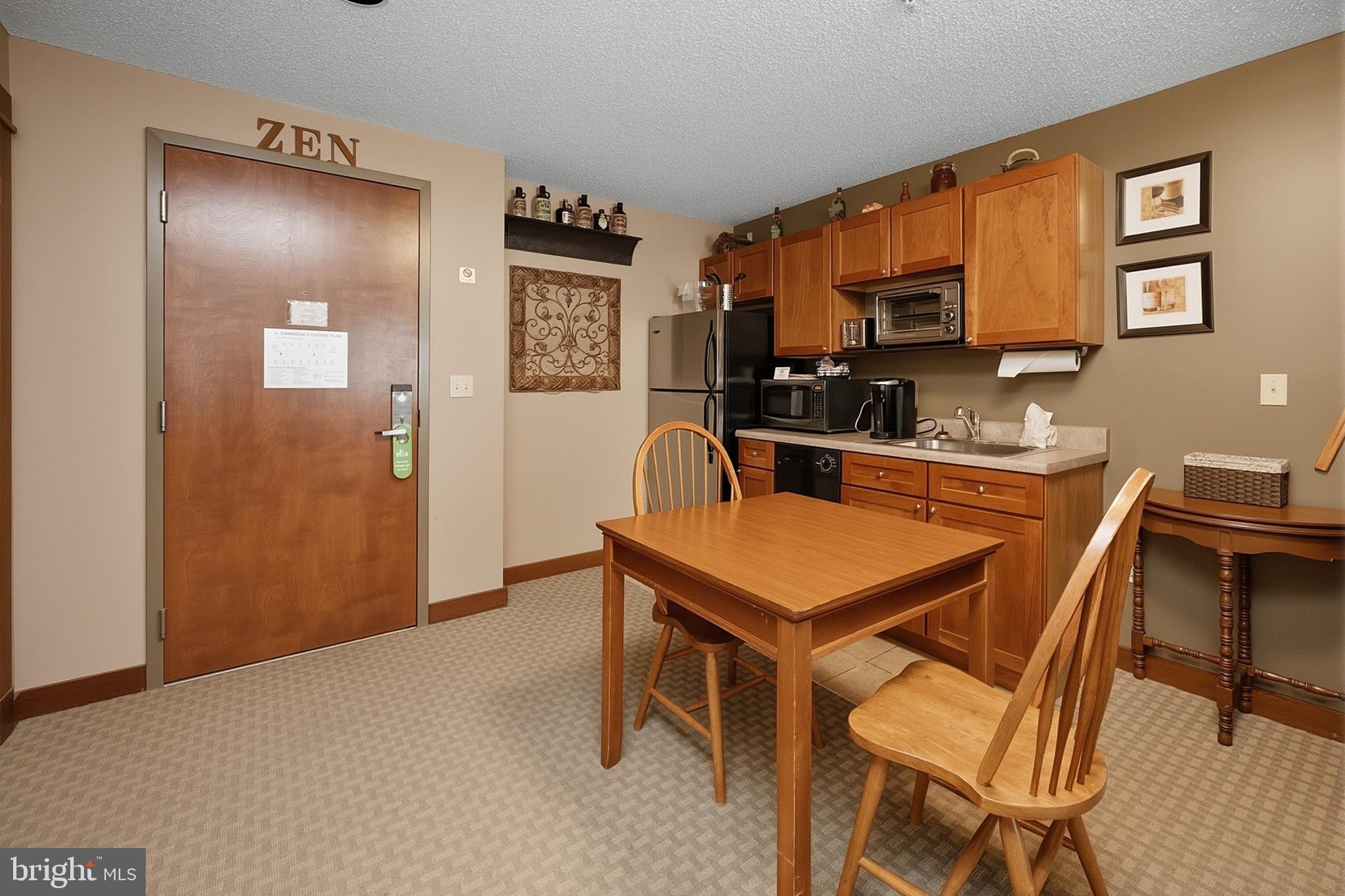 565 Glendale Road, Unit 208A Oakland, MD 21550 - Photo 10 of 51 a room with a table chairs and a refrigerator