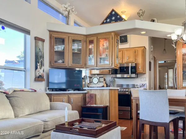 a living room with furniture large windows and a chandelier