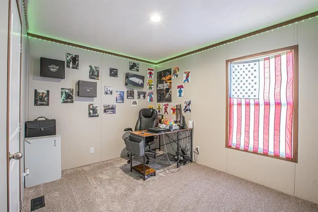 a view of a workspace with furniture and a window