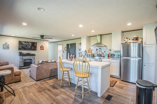 a kitchen with stainless steel appliances granite countertop a refrigerator and a stove top oven