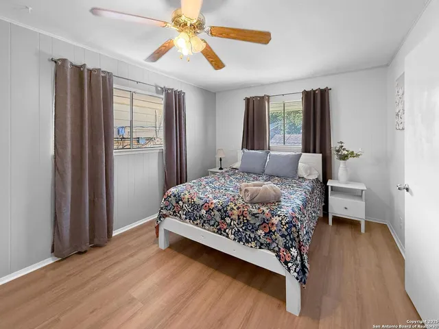 a bedroom with a bed chandelier and a window