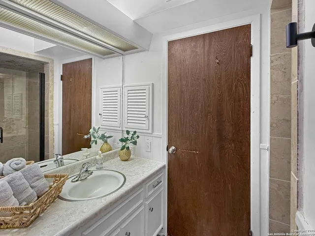 a bathroom with a granite countertop sink and a mirror