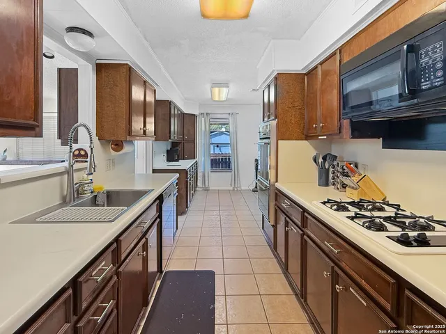 a kitchen with stainless steel appliances granite countertop a sink stove and cabinets