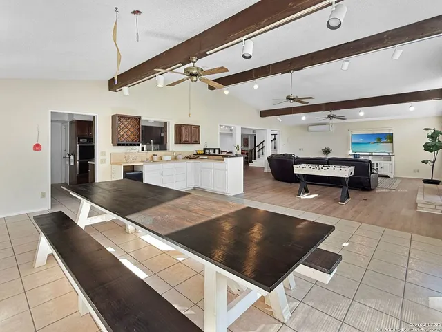 a large hall with stainless steel appliances kitchen island granite countertop a refrigerator and a stove top oven