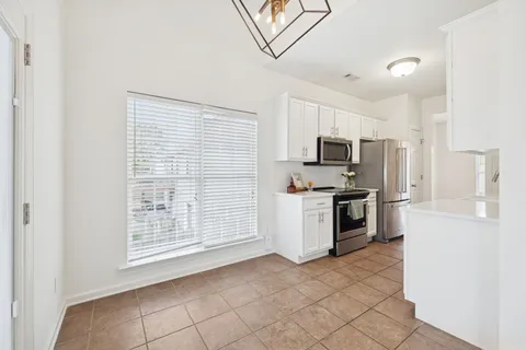 a kitchen with granite countertop a refrigerator and a stove top oven