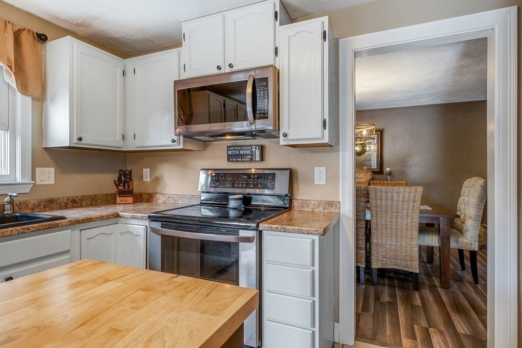 23 Balena Road Attleboro, MA 02703 - Photo 8 of 41 a kitchen with stainless steel appliances granite countertop a stove top oven a sink a microwave and cabinets
