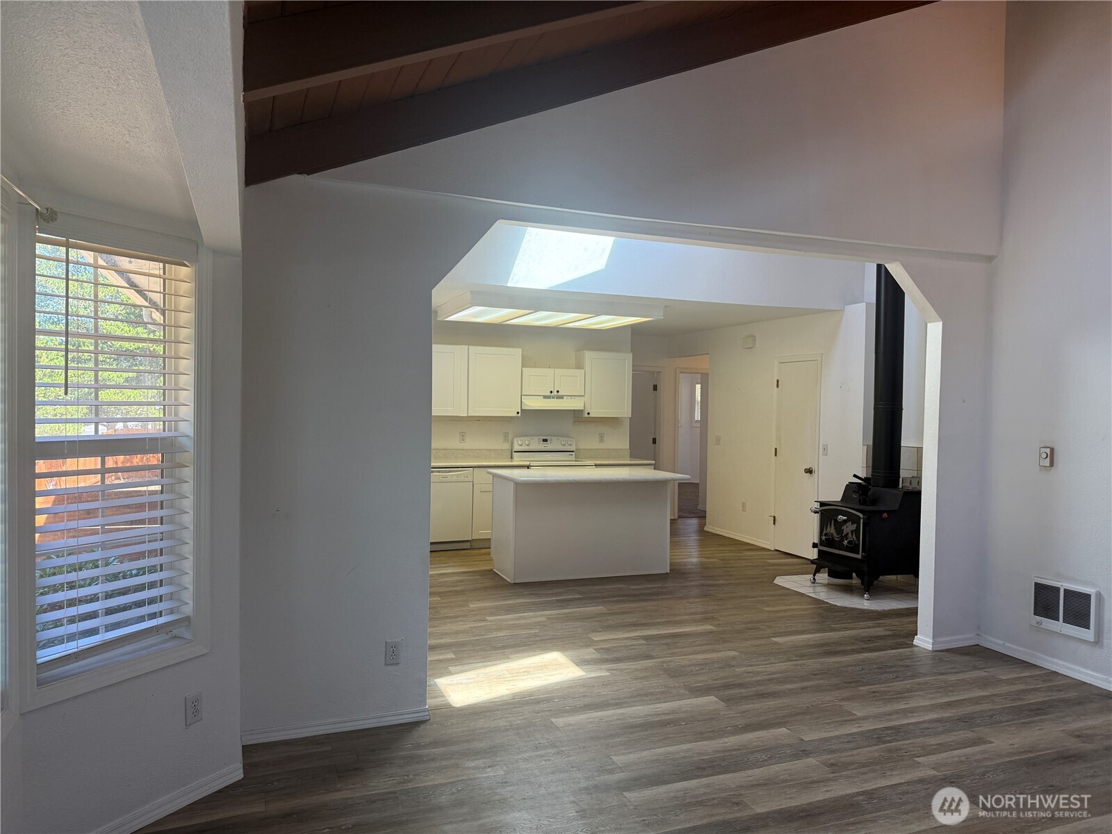 13208 Pacific Way Long Beach, WA 98631 - Photo 12 of 40 a view of a kitchen and an empty room with wooden floor and windows